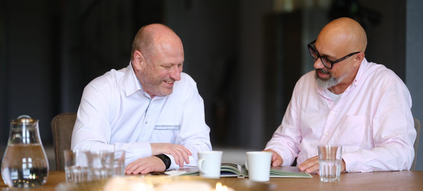 André Weiß und Markus Kerschis sehen gemeinsam Unterlagen durch